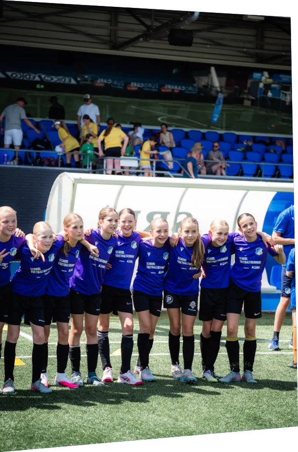 Meisjesteam staat arm in arm op het veld tijdens het ASML Schoolvoetbaltoernooi