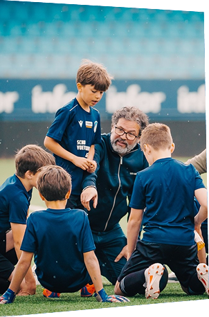 Schoolteam in teambespreking met de coach tijdens het ASML Schoolvoetbaltoernooi