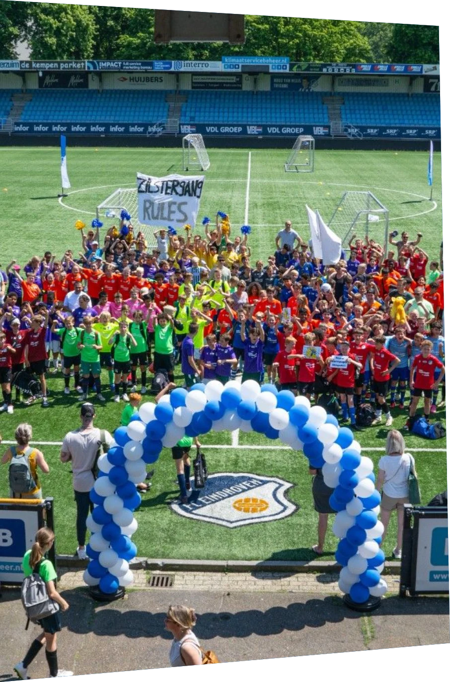Alle deelnemende schoolteams samen op het veld bij het ASML Schoolvoetbaltoernooi