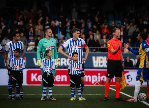 Kinderen lopen hand in hand met spelers het veld op tijdens de FC Eindhoven Line-Up
