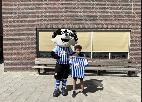 Woutje overhandigt de prijs van challenge 6 aan winnaar Lucas en zijn klas